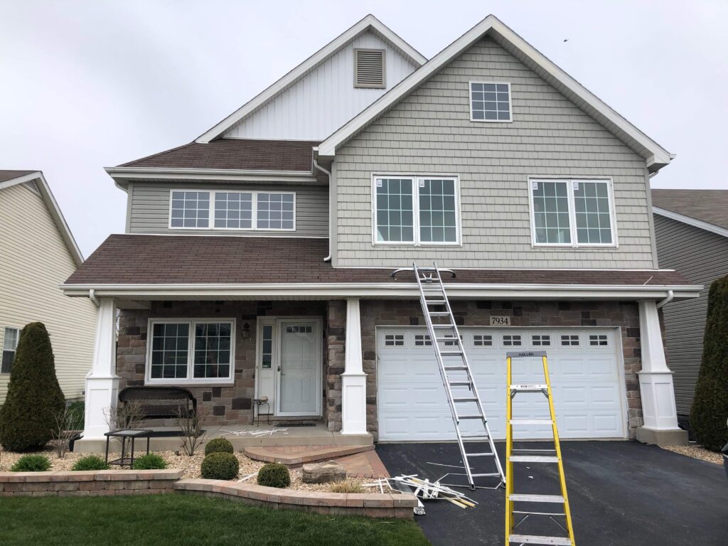 A residential home in Granger, IN that has just had a new roof installed by a contracting team. A home with a ladder resting on the edge of a roof that has been replaced.