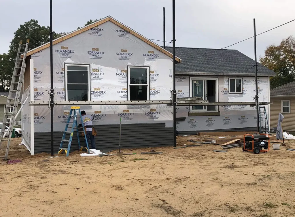 a home under construction in bridgman, mi with the vinyl siding being installed