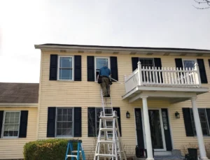 An Energy Efficient Replacements expert standing on a ladder while replacing a window in Goshen, IN